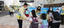 행복초등학교 정문에서 학생들에게 수첩을 나눠주고 있는 무안 군수와 직원들