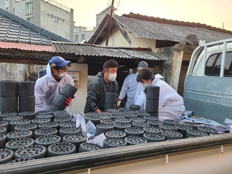 트럭에 연탄을 가득 싣고 나눔 봉사를 하고 있는 사진이다.